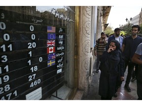 FILE - In this Oct. 2, 2018, file photo, an exchange shop displays rates for various currencies, in downtown Tehran, Iran. The Trump administration is closely eyeing efforts in Europe to set up an alternative money payment channel to ease doing business with Iran and avoid running afoul of sanctions the U.S. has levied on the Islamic republic.