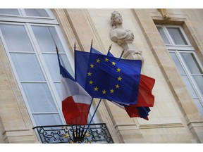FILE - In this Monday, Dec. 10, 2018 file picture European and French flags are flapping at the Elysee Palace in Paris, during a meeting with French President Emmanuel Macron and local, national political leaders, unions, business leaders and others to hear their concerns after four weeks of protests. French Prime Minister Edouard Philippe announced Thursday that the government will start hiring 600 extra government employees including customs agents to handle cross-border trade and security.