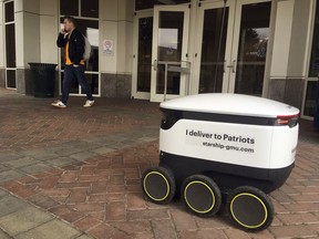 A Starship robot stands by at George Mason University campus in Fairfax, Va., Wednesday, Jan. 23, 2019.   A fleet of high-tech robots is now deployed at the northern Virginia university to serve the noble purpose of delivering pizza, doughnuts and coffee on demand to students who summon them.