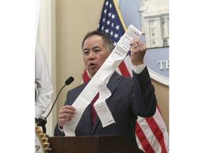 Assemblyman Phil Ting, D-San Francisco, displays a long paper receipt as he discusses his bill to require businesses to offer electronic receipts, Tuesday, Jan. 8, 2019, in Sacramento, Calif. Under the legislation customers could receive a paper receipt on request.