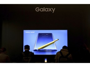 In this Wednesday, Jan. 30, 2019, photo, visitors try out Samsung Electronics' Galaxy Note9 smartphones during an industrial fair in Seoul, South Korea. South Korean technology giant Samsung posted on Thursday, Jan. 31, 2019, a near-30 percent drop in operating profit for the last quarter after seeing slowing global demand for its memory chips and smartphones.