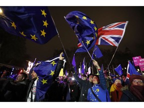 Anti-Brexit demonstrators react after the results of the vote on British Prime Minister Theresa May's Brexit deal were announced in Parliament square in London, Tuesday, Jan. 15, 2019. British lawmakers have rejected Prime Minister Theresa May's Brexit deal by a huge margin, plunging U.K. politics into crisis 10 weeks before the country is due to leave the European Union. The House of Commons voted 432 -202 on Tuesday against the deal struck between Britain's government and the EU in November.