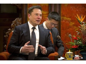 FILE - In this Jan. 9, 2019, file photo, Tesla CEO Elon Musk speaks during a meeting with Chinese Premier Li Keqiang at the Zhongnanhai leadership compound in Beijing. Electric car and solar panel maker Tesla said Friday, Jan. 18, 2019 it plans to cut its staff by about 7 percent.