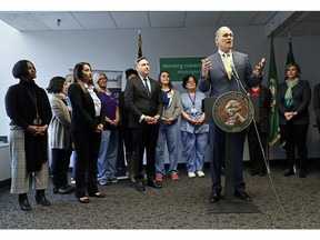 Washington Gov. Jay Inslee, front right, speaks at a news conference, Tuesday, Jan. 8, 2019, in Seattle. Inslee, a likely Democratic presidential candidate, announced a proposal for a public health insurance option for Washington state residents, the latest action by a Democratic governor to address Trump administration health policies they say are keeping people from getting the care they need.