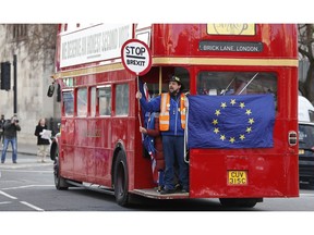 Anti Brexit protesters on board a hired red London bus demonstrate as they drive past the Houses of Parliament in London, Monday, Jan. 28, 2019. Pro-Brexit British lawmakers were mounting a campaign Monday to rescue May's rejected European Union divorce deal in a parliamentary showdown this week.