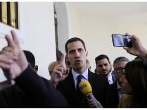 Opposition National Assembly President Juan Guaido, who has declared himself interim president of Venezuela, speaks with the media upon his arrival to National Assembly, in Caracas, Venezuela, Tuesday, Jan. 29, 2019. Venezuela's chief prosecutor on Tuesday asked the country's top court to ban opposition leader Guaido from leaving the country, launching a criminal probe into his anti-government activities while international pressure builds against President Nicolas Maduro.