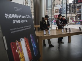 Customers look at iPhones on display at an Apple Store this week in Beijing, China.