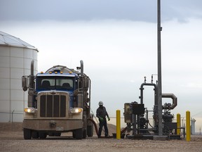 A worker unloads crude oil from a tanker at an Enterprise Crude Pipeline LLC storage facility in Loving County Texas. Once the shining star of the oil business, it has turned into such a drag on profits that U.S. refiners could be forced to slow production in response.