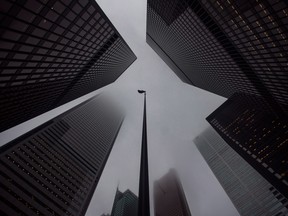 The Canadian flag blows in the wind in the heart of the financial district in Toronto.