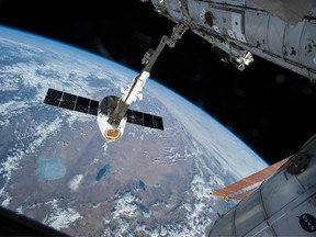 The Canadarm 2 reaches out to capture the SpaceX Dragon cargo spacecraft and prepare it to be pulled into its port on the International Space Station Friday April 17, 2015. Former Canadian company Maxar Technologies developed the Canadarm.