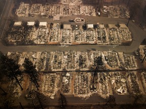 This Thursday, Nov. 15, 2018, file aerial photo shows the remains of residences leveled by the wildfire in Paradise, Calif. Facing potentially colossal liabilities over deadly California wildfires, PG&E will file for bankruptcy protection.