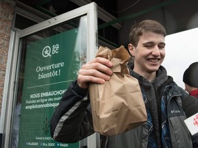 In this file photo taken on October 17, 2018 a young man holds a bag of marijuana he bought in a cannabis store in Quebec City, Quebec.