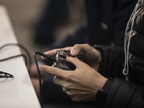 A gamer uses a controller to play Nintendo Co.'s Smash Bros. game.