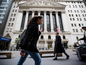 Pedestrians pass in front of Wall Street near the New York Stock Exchange (NYSE) in New York.