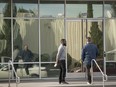 People stand outside an Apple Inc. satellite office building in Sunnyvale, Calif.