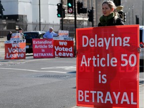 Demonstrators protest opposite the Houses of Parliament in London, Feb. 26, 2019. British Prime Minister Theresa May bowed to intense political pressure and handed control of Brexit to Parliament, telling lawmakers they will get to choose between leaving the EU on schedule — with or without a divorce deal — and asking the EU to postpone departure day.