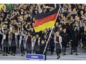 FILE - In this Friday, Aug. 5, 2016 file photo, Timo Boll carries the flag of Germany during the opening ceremony for the 2016 Summer Olympics in Rio de Janeiro, Brazil. Athletes in Germany have scored a victory over Olympic restrictions on games-times advertising. A German federal agency says "abusive" limits on Olympic promotional activities should be relaxed. The Federal Cartel Office says the Olympic Charter's rules are "too far-reaching and thus constitute abusive conduct."