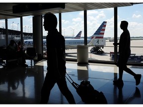 FILE - In this Aug. 1, 2016 file photo, passengers walk to their gates through the terminal as American Airlines planes wait to depart at O'Hare International Airport in Chicago. O'Hare International Airport was the busiest airport in the U.S. last year, surpassing Hartsfield-Jackson Atlanta International Airport for the first time in four years, according to data released Monday, Feb. 4, 2019, by the Federal Aviation Administration.