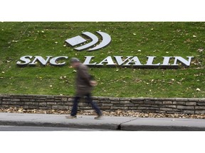 A man walks past the headquarters of SNC Lavalin in Montreal on November 6, 2014. For more than a century, SNC-Lavalin has been viewed with pride in Quebec as it grew from a small firm specializing in hydraulics into a global engineering and construction giant.Founded in 1911, it gained a reputation for building a large dam in Quebec that spearheaded the province's development of hydroelectricity and developing the skillsets for thousands of Quebec workers.