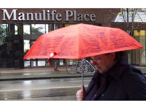 A pedestrian walks past the Manulife building in downtown Vancouver, B.C.,Thursday, May 3, 2012.