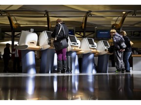 In this Jan. 30, 2017 file photo, passengers check in for Delta Air Lines flights at kiosks at Hartsfield-Jackson Atlanta International Airport in Atlanta.Canada's largest airlines are awaiting details from the federal government before they follow their U.S. counterparts in allowing travellers to choose gender designations outside the traditional "male" and "female" check-in categories.