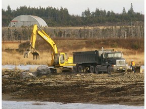 Workers repair the road leading to the Donkin coal mine in Donkin, N.S., on Monday Dec. 13, 2004. Officials at an undersea Cape Breton coal mine broke a provincial regulation by not reporting a massive roof cave-in until government inspectors showed up 15 days after the first rock crashed down, according to provincial documents citing the firm for contravening rules last fall.