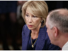 Education Secretary Betsy DeVos, talks with Louisiana Gov. John Bel Edwards before President Donald Trump arrives to speak at the 2019 White House Business Session with Our Nation's Governors in the State Dining Room of the White House in Washington, Monday, Feb. 25, 2019.