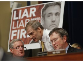 Rep. Jim Jordan, R-Ohio, center, ranking member of the Committee on Oversight and Reform talks with Rep. Mark Meadows, R-N.C., left, and Rep. Thomas Massie, R-Ky., right, during testimony by Michael Cohen, President Donald Trump's former personal lawyer on Capitol Hill in Washington, Wednesday, Feb. 27, 2019.