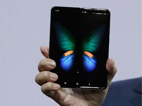 DJ Koh, Samsung President and CEO of IT and Mobile Communications, holds up the new Galaxy Fold smartphone during an event Wednesday, Feb. 20, 2019, in San Francisco.