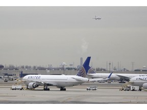 FILE - In this Wednesday, Jan. 23, 2019 file photo, United Airlines jets are seen as a plane approaches Newark Liberty International Airport, in Newark, N.J. United Airlines will woo high-fare passengers by retrofitting more than 100 planes to add more premium seats on key routes. United announced the moves Wednesday, Feb. 6, 2019.
