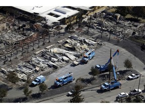 FILE - In this Oct. 14, 2017, file photo, crews of Pacific Gas & Electric Corp. work on restoring power lines in a fire ravaged neighborhood in an aerial view in the aftermath of a wildfire in Santa Rosa, Calif. The nation's largest utility on Wednesday, Feb. 6, 2019, promised to overhaul its wildfire-prevention measures in response to growing legal, financial and public pressure for its role in starting some of the most destructive blazes in California history.