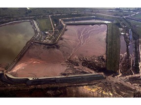 FILE - In this Monday, Oct. 11, 2010 file photo, the damaged reservoir of an alumina plant is seen from the air near the village of Kolontar, Hungary. A Hungarian court on Monday Feb. 4, 2019, has sentenced to prison two former executives of an alumina plant involved in the 2010 red sludge flood, an industrial disaster which killed eight people and injured over 220.