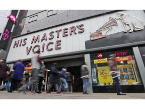 FILE - In this file photo dated Friday, Dec. 28, 2018, people pass a CD music and entertainment retailer HMV shop in London. HMV has been acquired out of administration by Canadian retailer Sunrise Records, it is announced Tuesday Feb. 5, 2019, safeguarding the future of nearly 1,500 staff, although it is understood that some unprofitable stores will close with immediate effect.