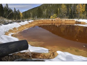 In this Oct. 12, 2018 photo, water contaminated with arsenic, lead and zinc flows from a pipe out of the Lee Mountain mine and into a holding pond near Rimini, Mont. The community is part of the Upper Tenmile Creek Superfund site, where dozens of abandoned mines have left water supplies polluted and residents must use bottled water.