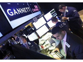 FILE - In this Aug. 5, 2014, file photo, specialist Michael Cacace, foreground right, works at the post that handles Gannett on the floor of the New York Stock Exchange. Gannett, publisher of USA Today, said Monday, Feb. 4, 2019, that its board has unanimously rejected a $1.36 billion buyout offer from a media group with a history of taking over struggling newspapers and slashing jobs.