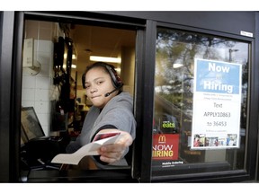FILE- In this Jan. 3, 2019, file photo a cashier returns a credit card and a receipt at a McDonald's window, where signage for job openings are displayed in Atlantic Highlands, N.J. On Tuesday, Feb. 12, the Labor Department reports on job openings and labor turnover for December.
