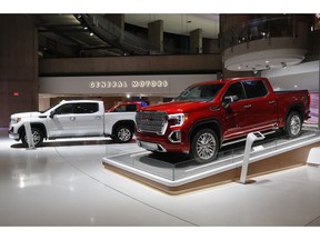 FILE- This Jan. 16, 2019, file photo shows a GMC Sierra pickup, left, and Denali in Detroit.  General Motors' posted an $8.1 billion net profit last year as it got better prices for vehicles sold in the U.S., its most lucrative market. The performance was far better than the previous year, when the company lost $3.9 billion due to a giant tax accounting charge.