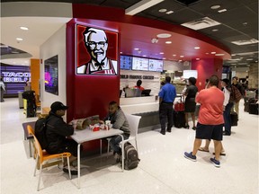 FILE- In this Oct. 17, 2017, file photo, customers line up at a Kentucky Fried Chicken restaurant inside Miami International Airport in Miami. Yum Brands, Inc., which operates Taco Bell, KFC and Pizza Hut, reports financial results Thursday, Feb. 7, 2019.