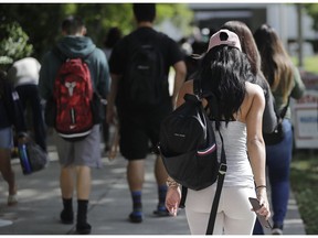 FILE- In this Oct. 23, 2018, file photo, students walk on the campus of Miami Dade College, in Miami. The nine companies and organizations tasked with servicing the accounts of the nation's 30 million student loan borrowers repeatedly failed to do their jobs properly over a period of years and their regulator neglected to hold them responsible, a new report finds. The report released Thursday, Feb. 14, 2019, by the Department of Education's independent Inspector General's office shows some borrowers weren't getting the guidance and protection they needed as they sought the best plan for paying off their student loans.