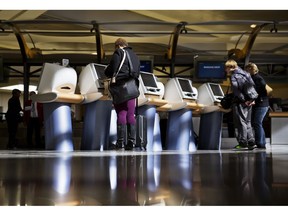 FILE - In this Jan. 30, 2017 file photo, passengers check in for Delta Air Lines flights at kiosks at Hartsfield-Jackson Atlanta International Airport in Atlanta. Major U.S. airlines say they will soon change their ticketing process to give passengers an option to identifying themselves as male or female. The gender option on airline sites will soon include choices such as "Mx." or "undisclosed." American, Delta and United confirmed Friday, Feb. 15, 2019, that they are in the process of updating their booking tools to add such an option. They said the change will be made in the next several weeks.