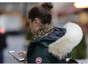 In  this Feb. 14, 2019 photo, a woman in New York wears a Canada Goose coat with the hood trimmed in coyote fur. The fur-trimmed parkas so common on city sidewalks have become a boon to backwoods trappers. The rising demand for coyote fur is largely attributed to its use on Canada Goose parkas.