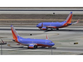 FILE - In this Sept. 4, 2013 file photo, a Southwest Airlines Boeing 737 takes off, rear, as another taxis in the north runway complex at Los Angeles International Airport (LAX). The airline says it has gained government approval to begin flights between California and Hawaii, capping a long effort that was delayed by the government shutdown. The airline's chief operating officer, Mike Van de Ven, told employees Wednesday, Feb. 27, 2019, that the Federal Aviation Administration granted the authorization.