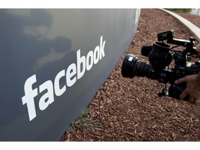 FILE - In this May 18, 2012, file photo a television photographer shoots the sign outside of Facebook headquarters in Menlo Park, Calif. A parliamentary committee report published Sunday, Feb. 17, 2019, has recommended that the United Kingdom government increase oversight of social media platforms like Facebook to better control harmful or illegal content.