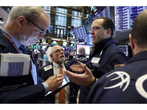 FILE- In this Feb. 15, 2019, file photo specialist Anthony Matesic, right, works with traders on the floor of the New York Stock Exchange. The U.S. stock market opens at 9:30 a.m. EST on Wednesday, Feb. 20.