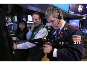 FILE- In this Tuesday, Jan. 29, 2019, file photo specialist Specialist Glenn Carell, center, and trader John Panin work on the floor of the New York Stock Exchange. The U.S. stock market opens at 9:30 a.m. EST on Thursday, Feb. 7.
