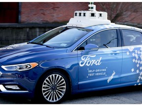 In this Dec. 18, 2018, photo one of the test vehicles from Argo AI, Ford's autonomous vehicle unit, navigates through the strip district near the company offices in Pittsburgh. Even the most optimistic experts say it will be 10 years before self-driving vehicles are everywhere, but others believe it will take decades. The biggest reasons are camera and laser sensors that can't see through heavy snow or figure out where to go if lane lines are covered.