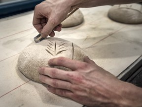 Brodflour head baker Will Ballantyre-Rice scores bread before it bakes.