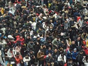 People walk through a railway station in China.