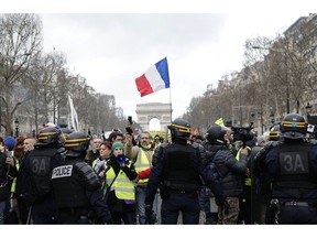 Yellow vest protesters walk down the famed Champs Elysees avenue to keep pressure on French President Emmanuel Macron's government, for the 13th straight weekend of demonstrations, in Paris, France, Saturday, Feb. 9, 2019.