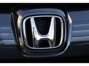 FILE - In this  Jan. 11, 2016, file photo, the logo of Honda Motor Co. is seen on a Honda vehicle at the Japanese automaker's headquarters in Tokyo. The Japanese automaker reported a 71 percent decline in fiscal third-quarter profit as air-bag recalls and flat vehicle sales eroded the benefits of cost cuts.